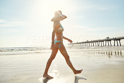 Buy stock photo Shot of an attractive young woman walking on the beach