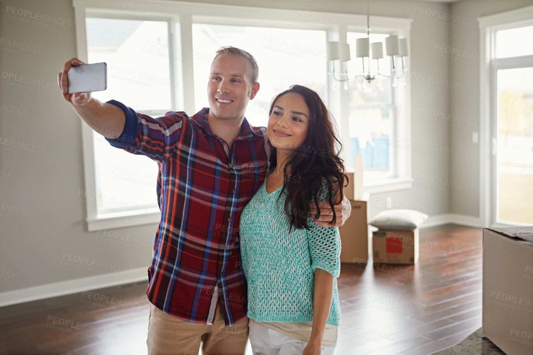 Buy stock photo Shot of a young couple moving into their new home