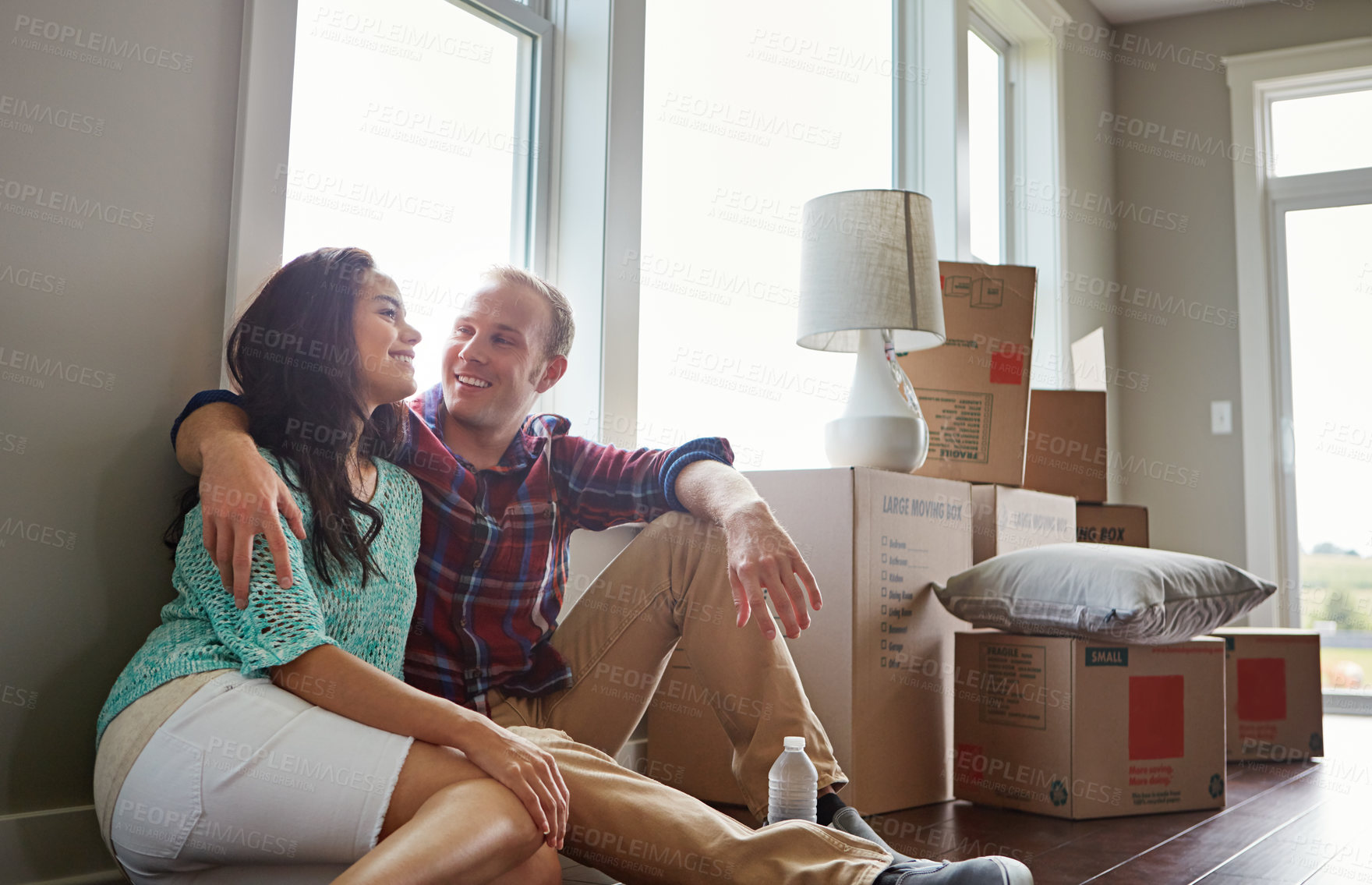 Buy stock photo Shot of a young couple moving into their new home