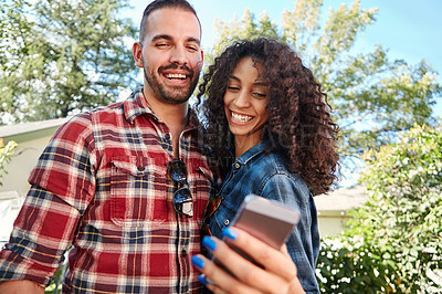 Buy stock photo Shot of a young couple taking a selfie outside