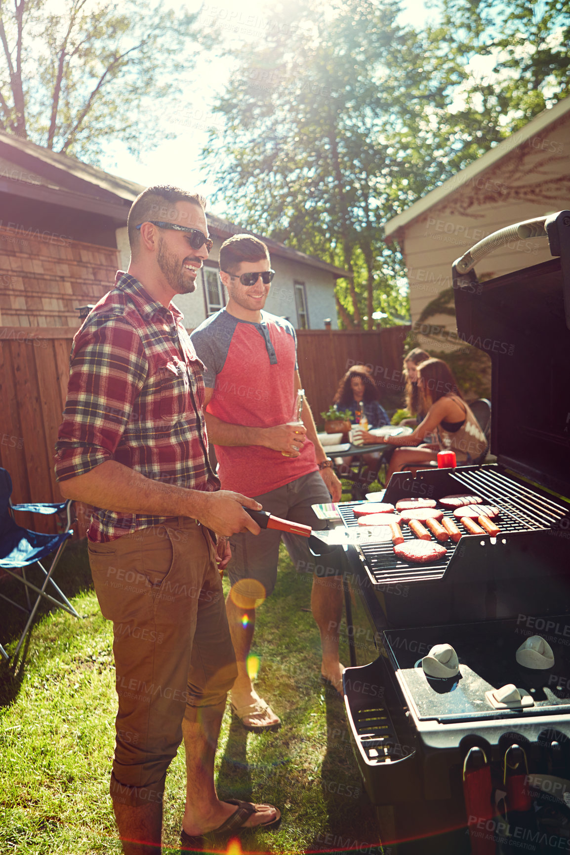 Buy stock photo Shot of friends having a barbecue outside