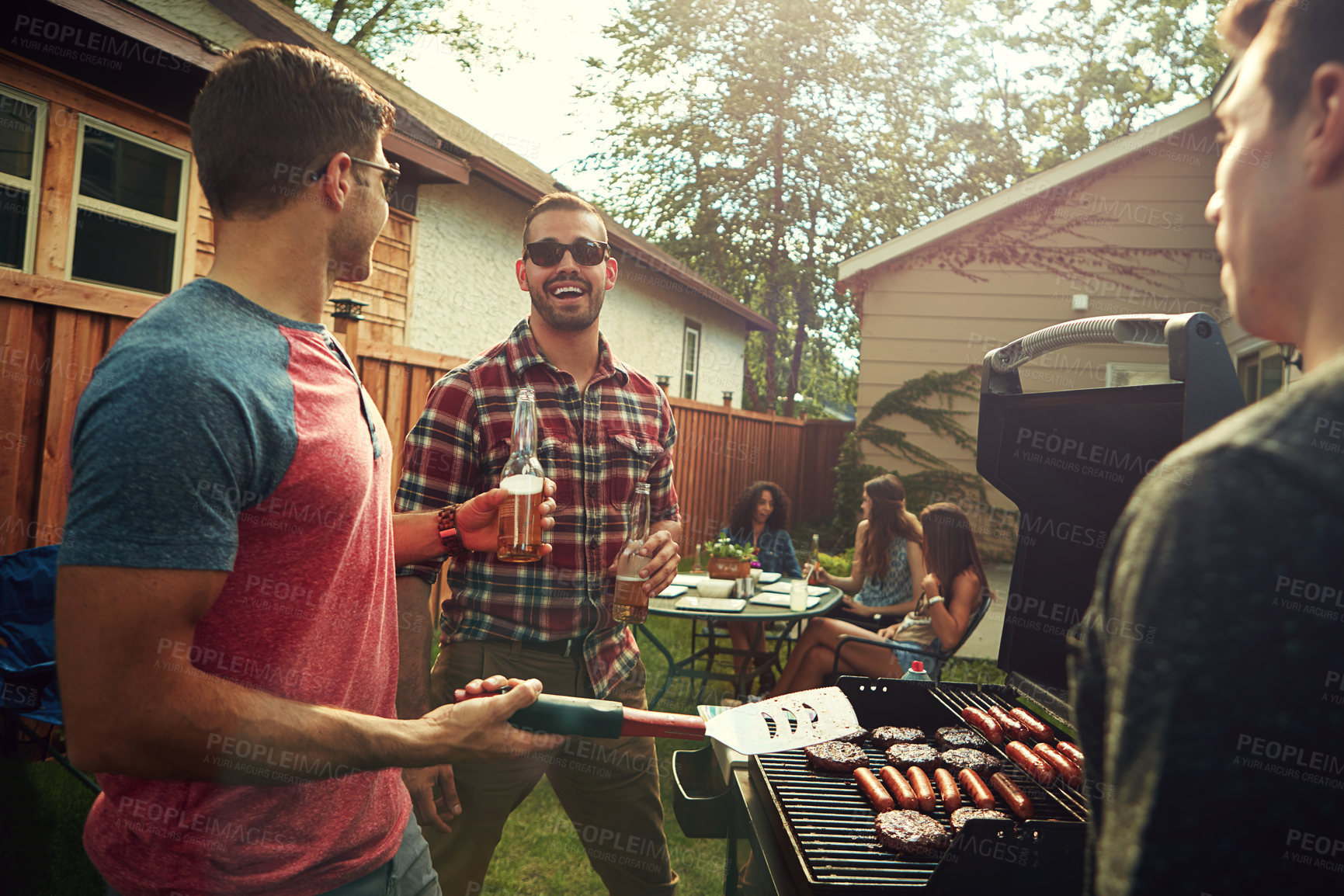 Buy stock photo Shot of a group of friends having a barbecue outside