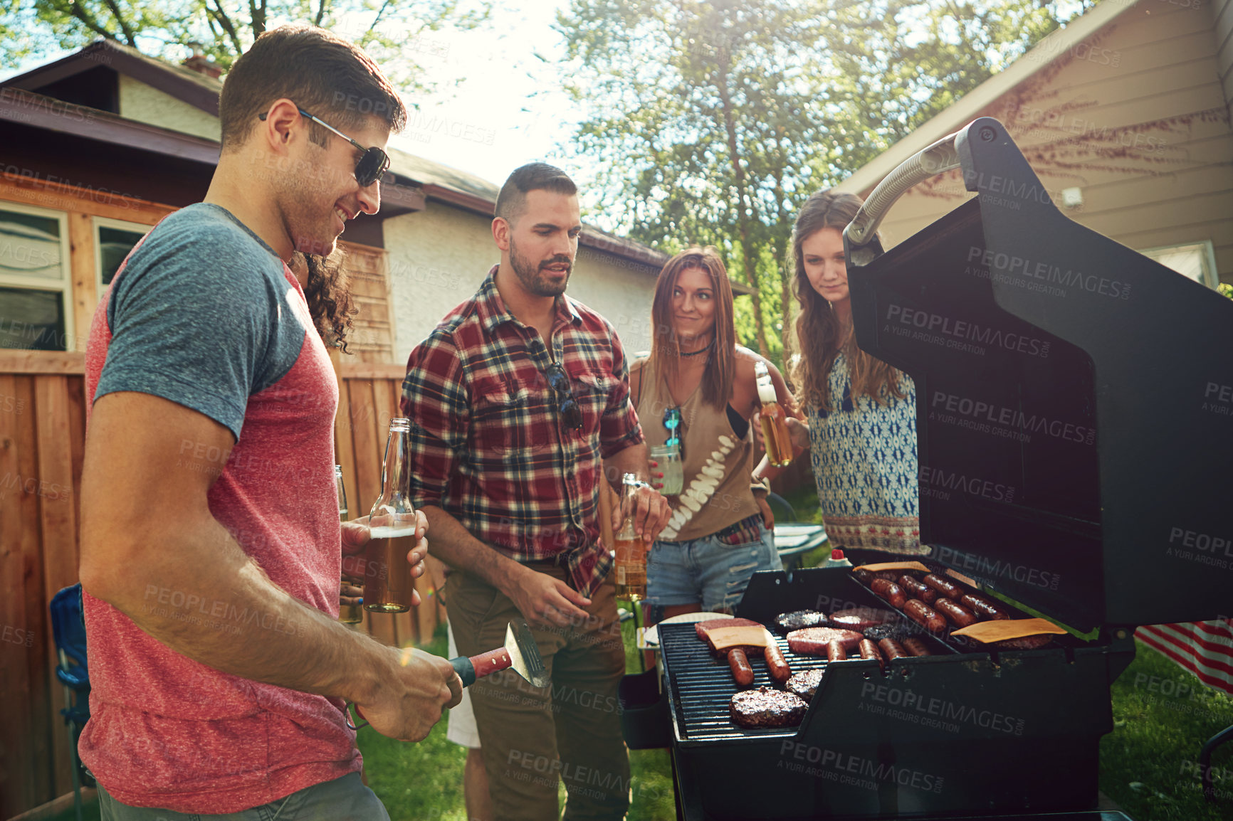 Buy stock photo Shot of a group of friends having a barbecue outside