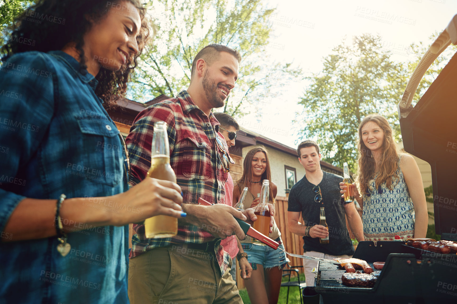 Buy stock photo Shot of a group of friends having a barbecue outside