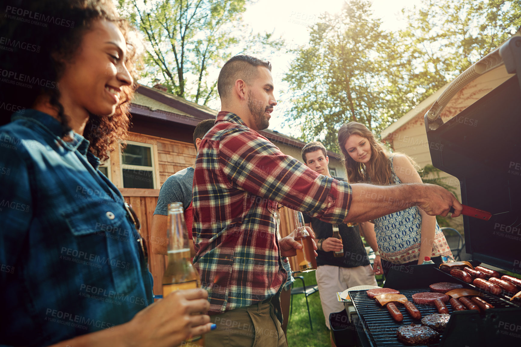 Buy stock photo Shot of a group of friends having a barbecue outside