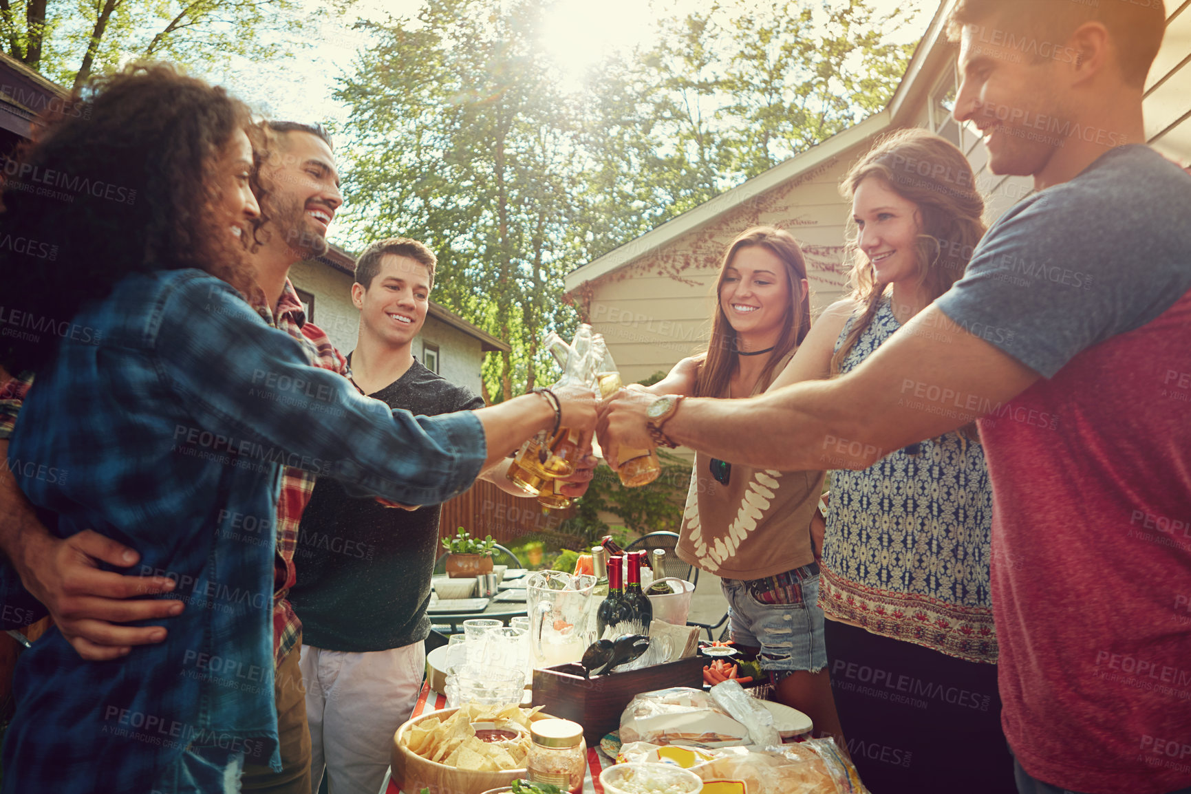 Buy stock photo Shot of a group of friends having lunch in their backyard