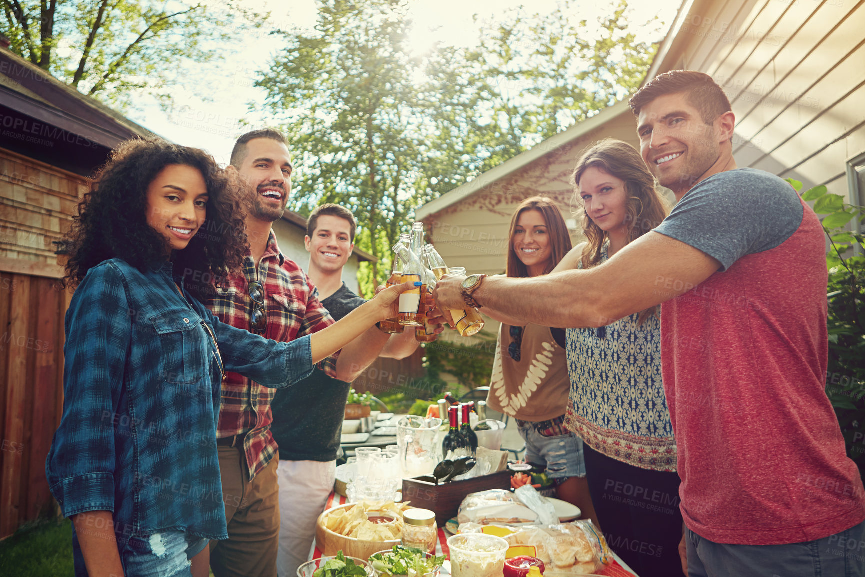 Buy stock photo Shot of a group of friends having lunch in their backyard