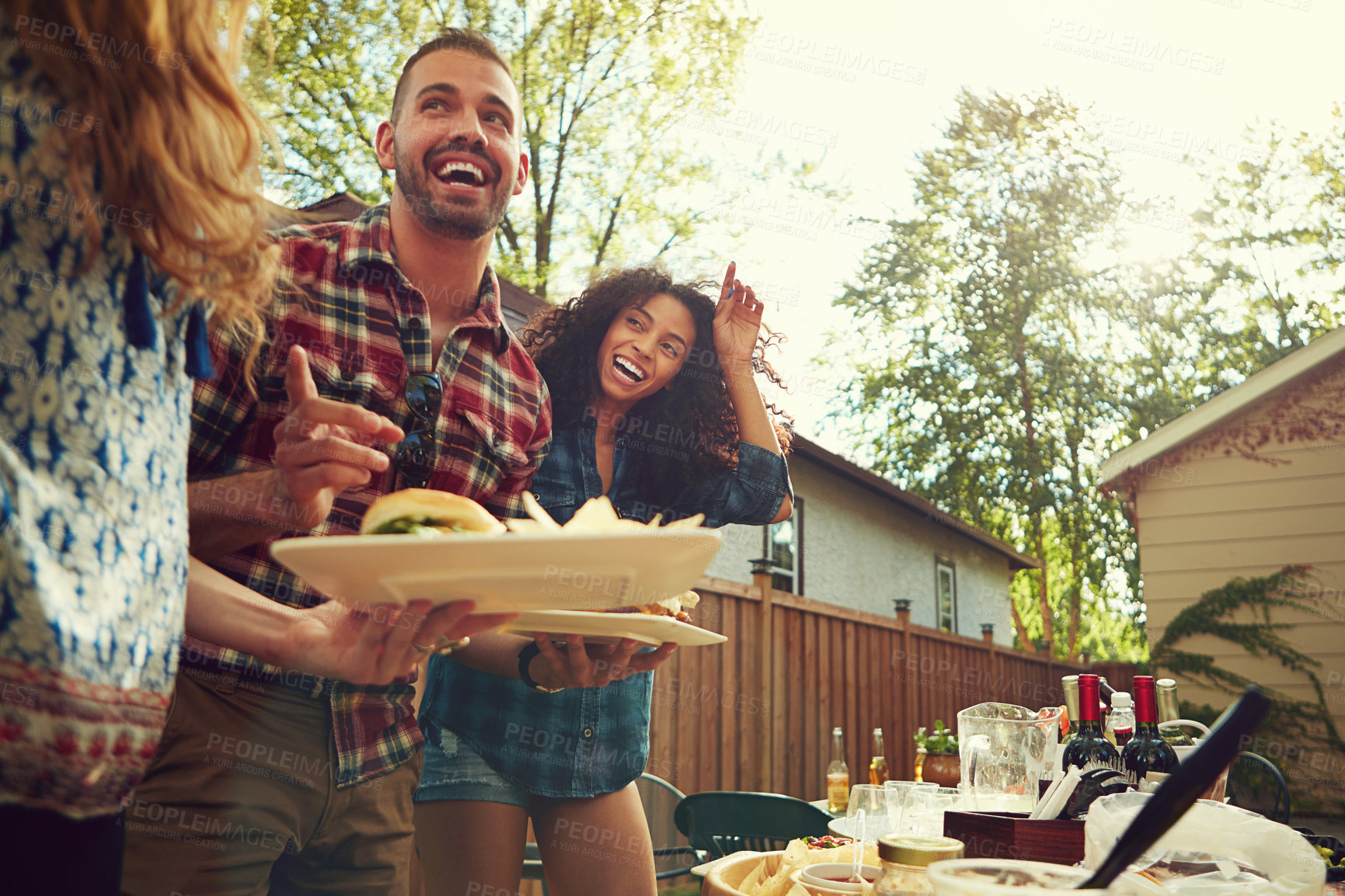 Buy stock photo Shot of a group of friends having lunch in their backyard