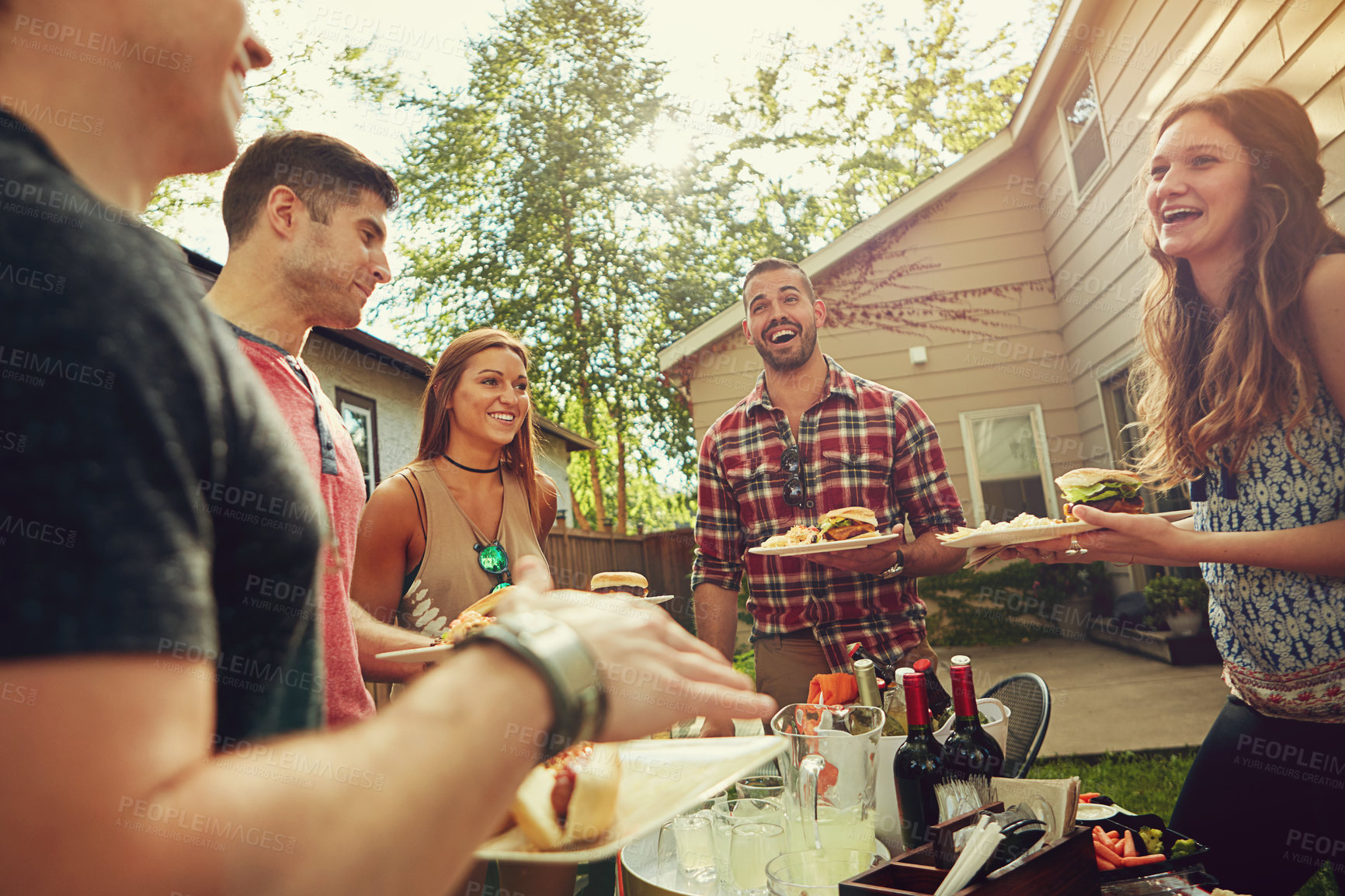 Buy stock photo Shot of a group of friends having lunch in their backyard