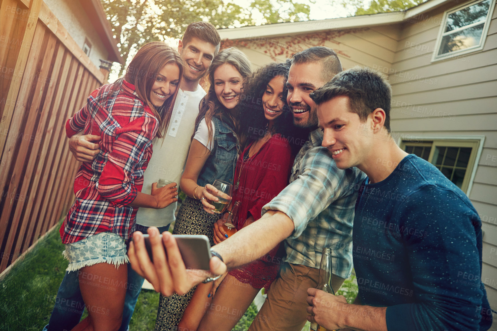 Buy stock photo Shot of a group of friends taking a selfie outside