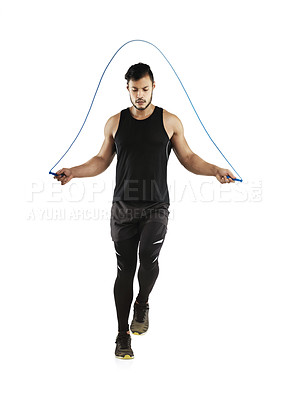 Buy stock photo Studio shot of a young man skipping with a jump rope against a white background