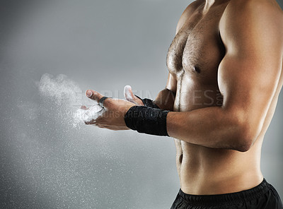 Buy stock photo Cropped studio shot of a man dusting his hands with chalk before a fight