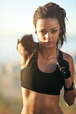 Buy stock photo Woman, portrait and fist punch for boxing workout in nature park with earphones for music, listening or confidence. Female person, face and hands for fighter practice with radio, playlist or audio