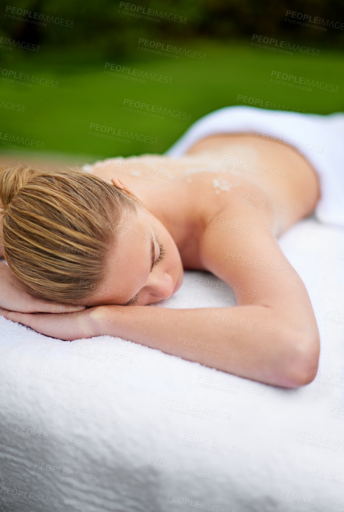 Buy stock photo Woman, relaxing and table in spa with salt, therapy and self care for body wellness and resting for tension. Comfortable and resort and client, treatment and healing, exfoliate session or cosmetology