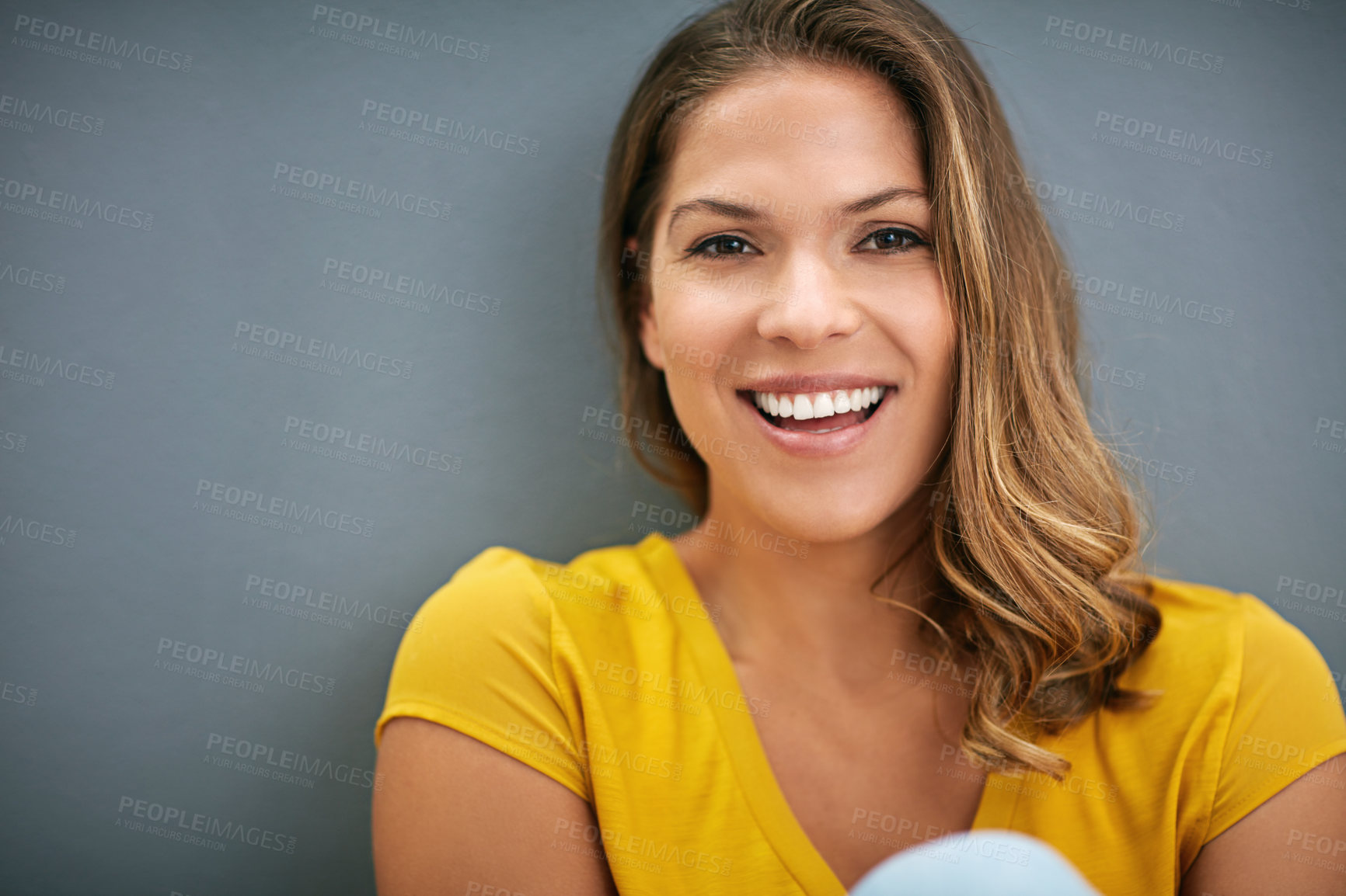 Buy stock photo Shot of a young woman posing against a gray wall