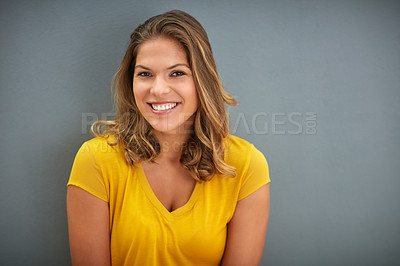 Buy stock photo Shot of a young woman posing against a gray wall