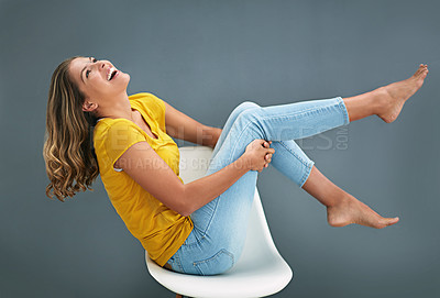Buy stock photo Studio, fashion and girl on chair, playful and fun for clothes, streetwear and comfortable in wall. Crazy, cool and person on stool, laugh and happiness for tshirt, weekend and grey background in USA