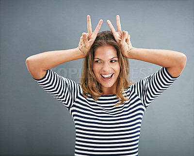 Buy stock photo Woman, bunny ears and fingers in studio for funny joke, happy and play on gray background. Female person, emoji and rabbit icon or symbol for comedy, comic gesture and mockup space for easter humor