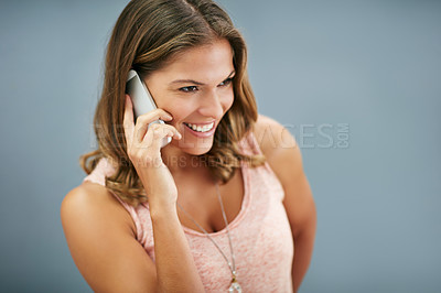 Buy stock photo News, phone call and happy woman talking in studio for story, gossip or discussion isolated on a gray background. Mobile, smile and model in conversation, chat and listening to contact information