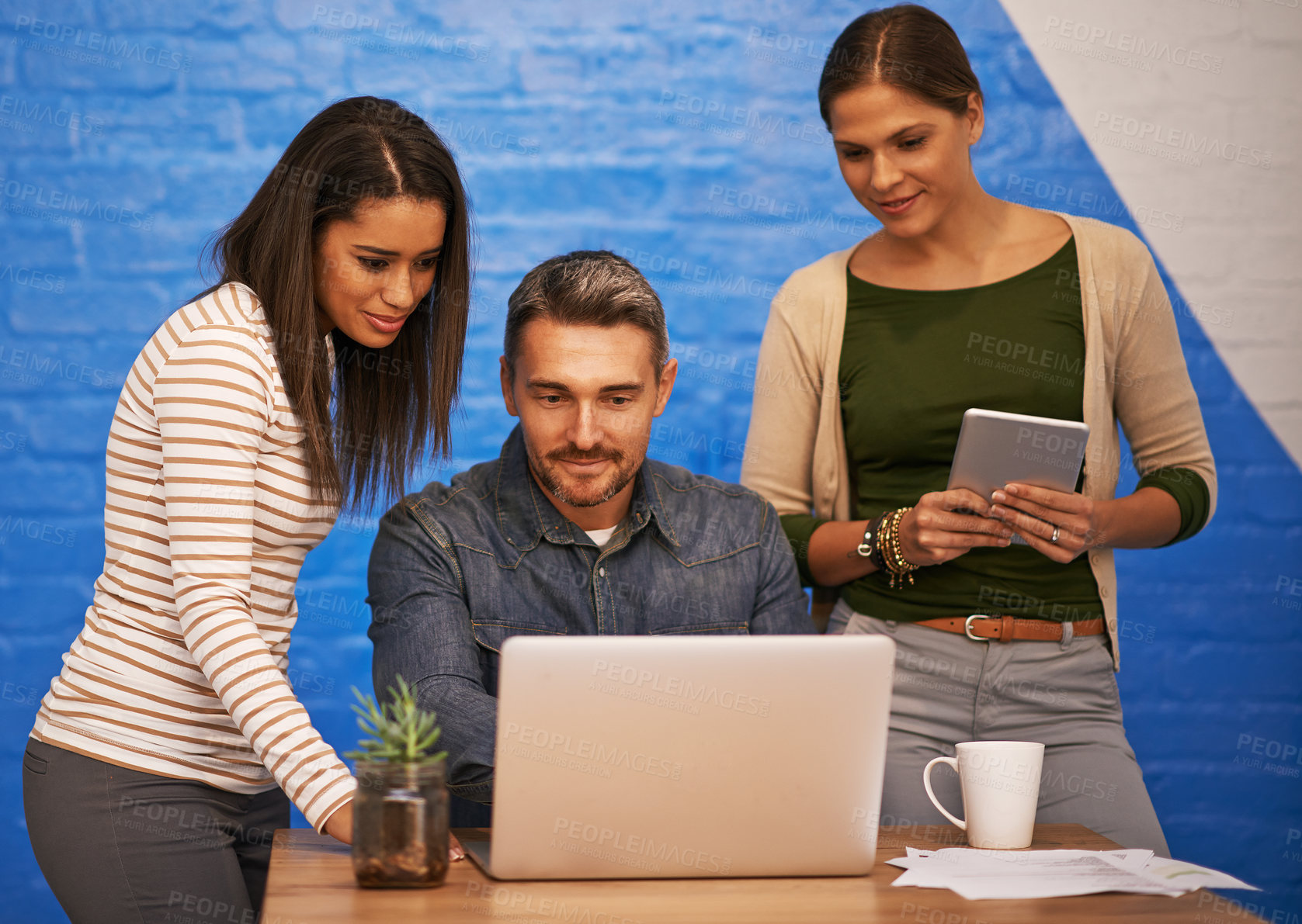 Buy stock photo Shot of three businesspeople having a quick meeting