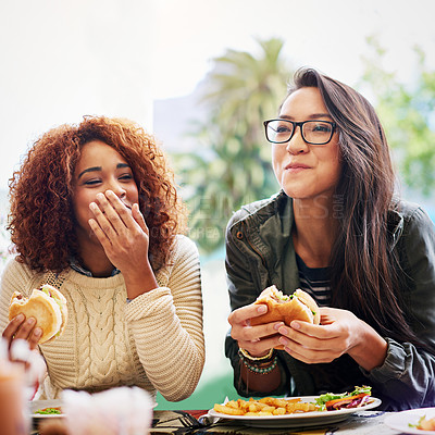 Buy stock photo Cropped shot of two girlfriends eating burgers outdoors