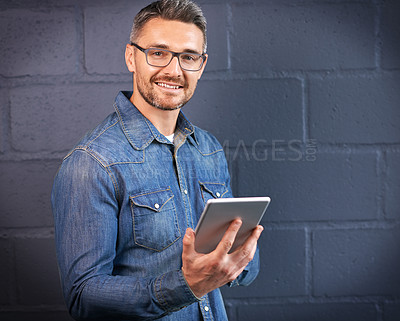 Buy stock photo Portrait of a man using a digital tablet against a brick wall background