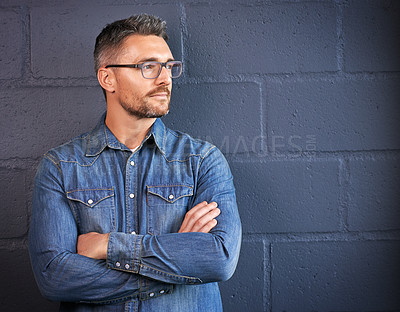 Buy stock photo Shot of a confident man posing against a brick wall background