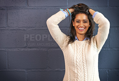 Buy stock photo Cropped portrait of a young woman posing against a brick wall background