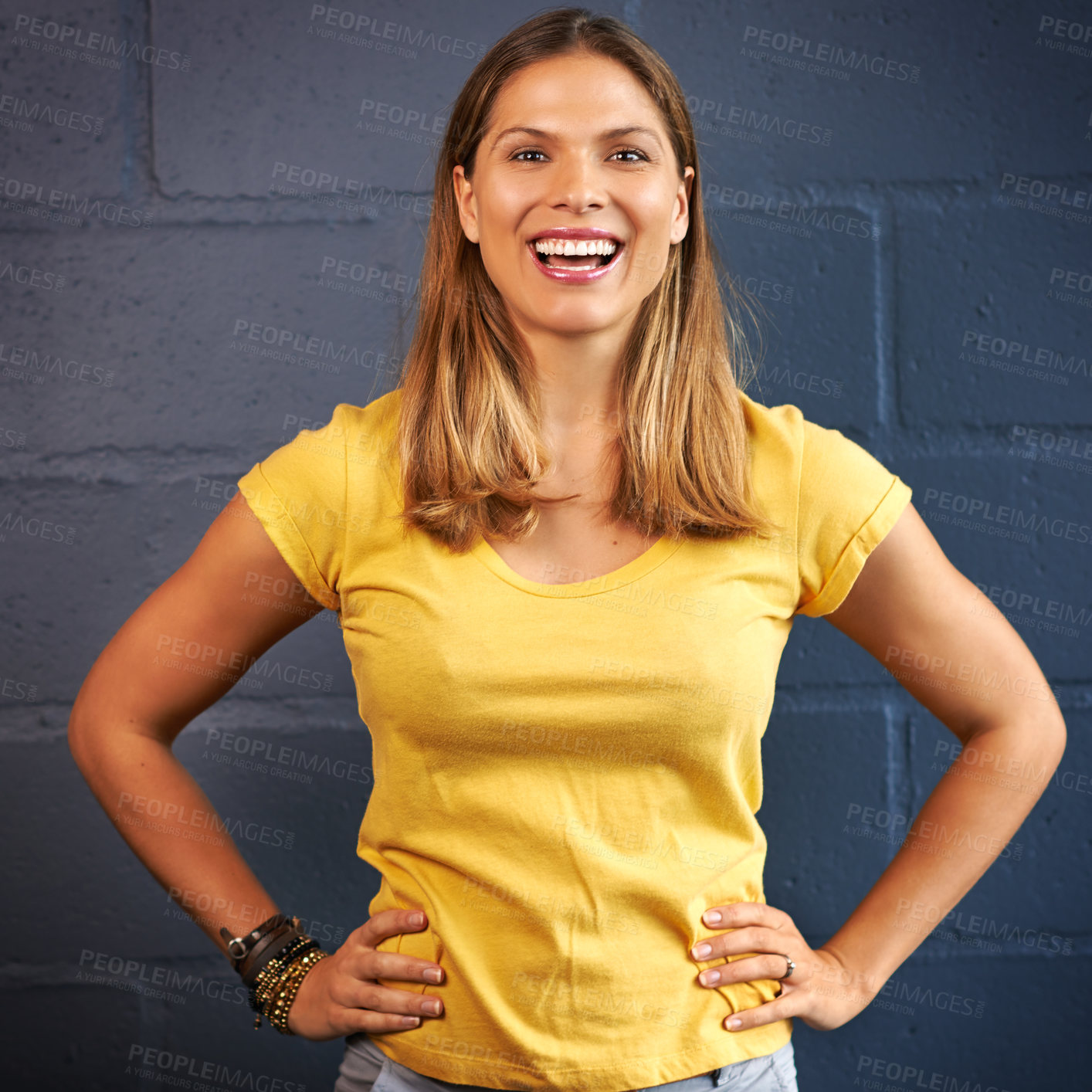 Buy stock photo Cropped portrait of a young woman posing against a brick wall background