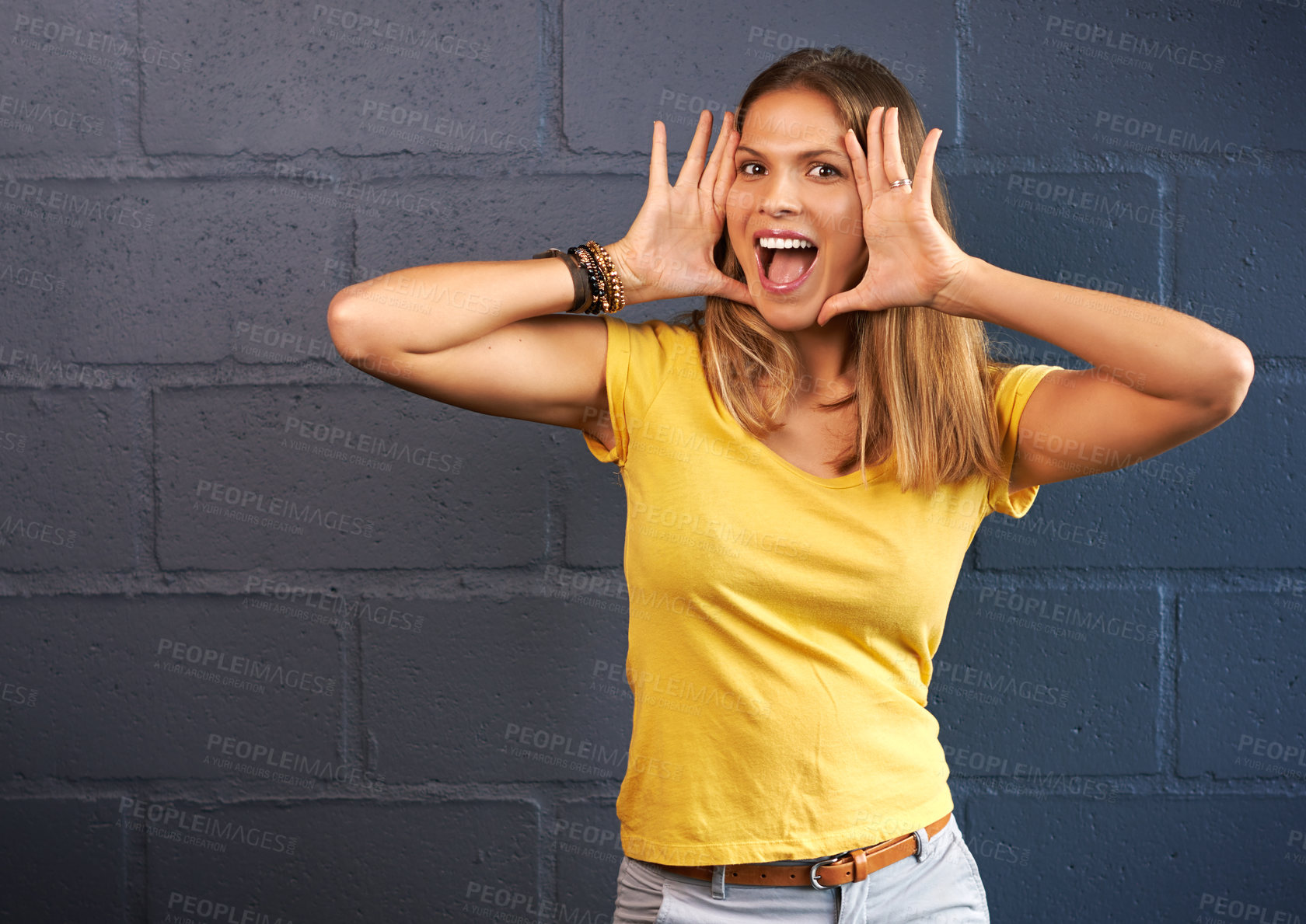 Buy stock photo Cropped portrait of a young woman shouting against a brick wall background