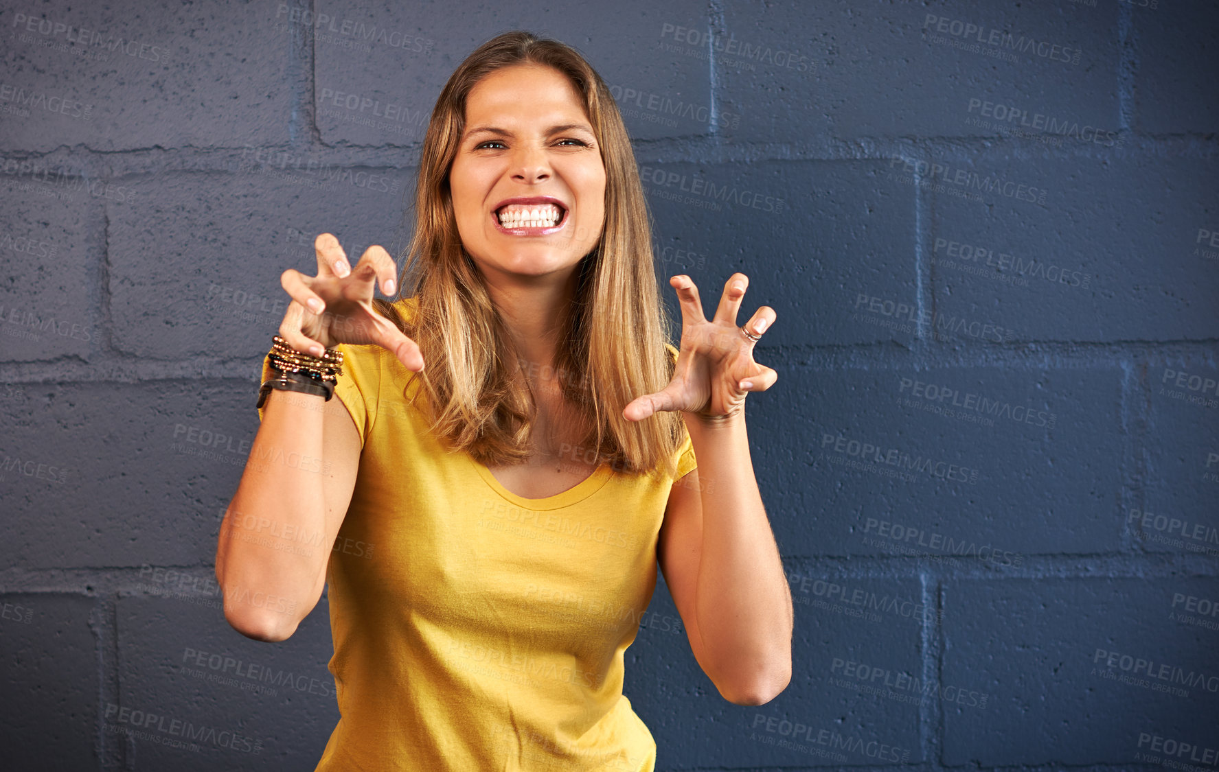 Buy stock photo Woman, happy portrait and hand claws with mockup, fun entertainment and wellness by brick wall. Female person, excited smile and animal gesture with space, scratch and isolated by dark background