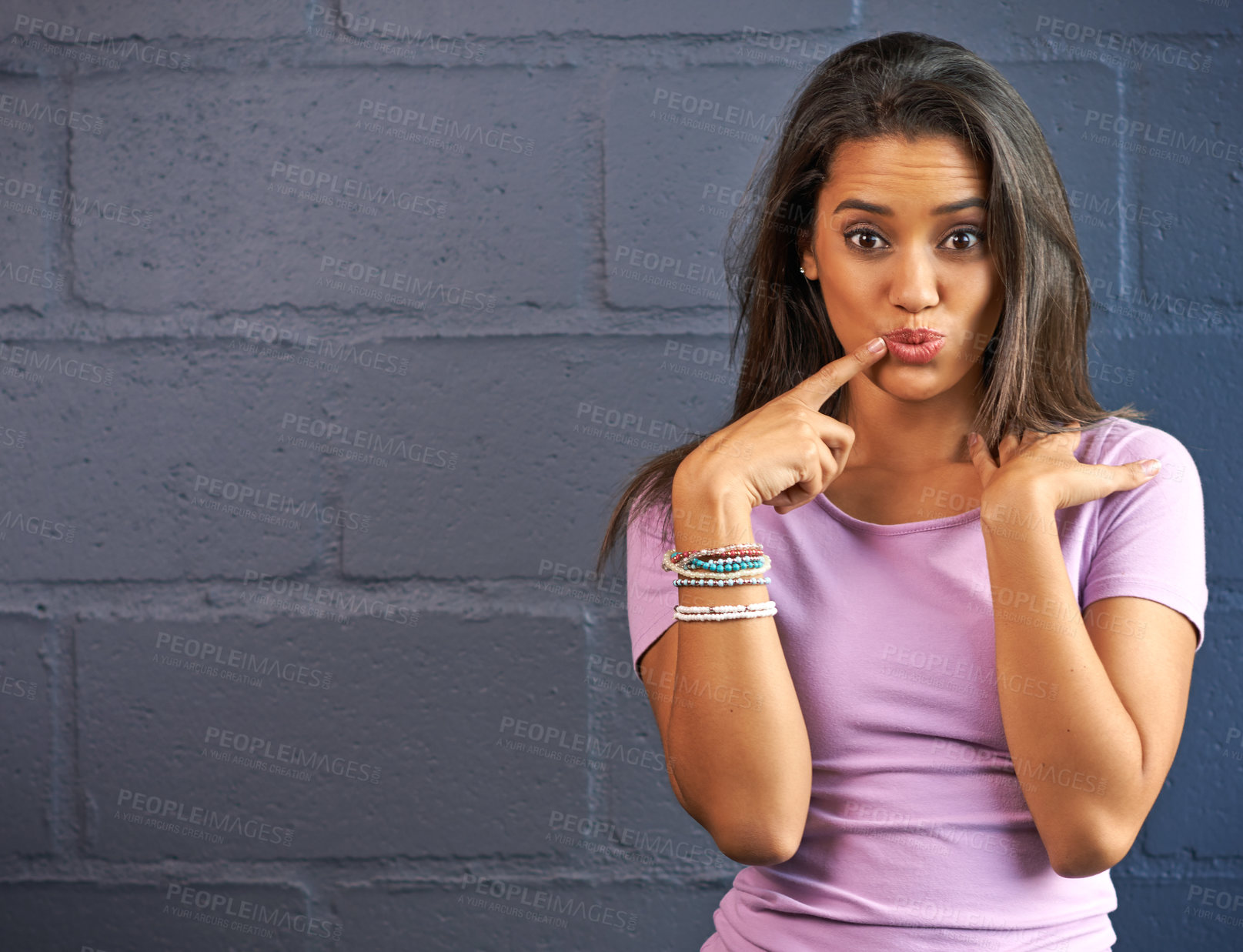 Buy stock photo Woman, thinking portrait and finger by lips for ideas, inspiration and mockup by brick wall. Female person, happy and thoughtful with space, hand on mouth and surprise for insight by dark background