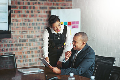 Buy stock photo Cropped shot of a young businesswoman looking at a table while standing over a colleague's desk