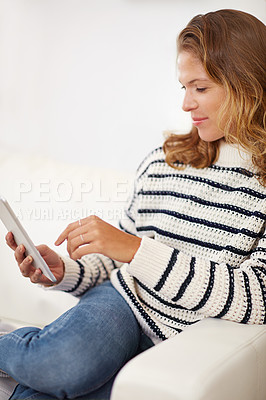 Buy stock photo Shot of a young woman using her digital tablet at home