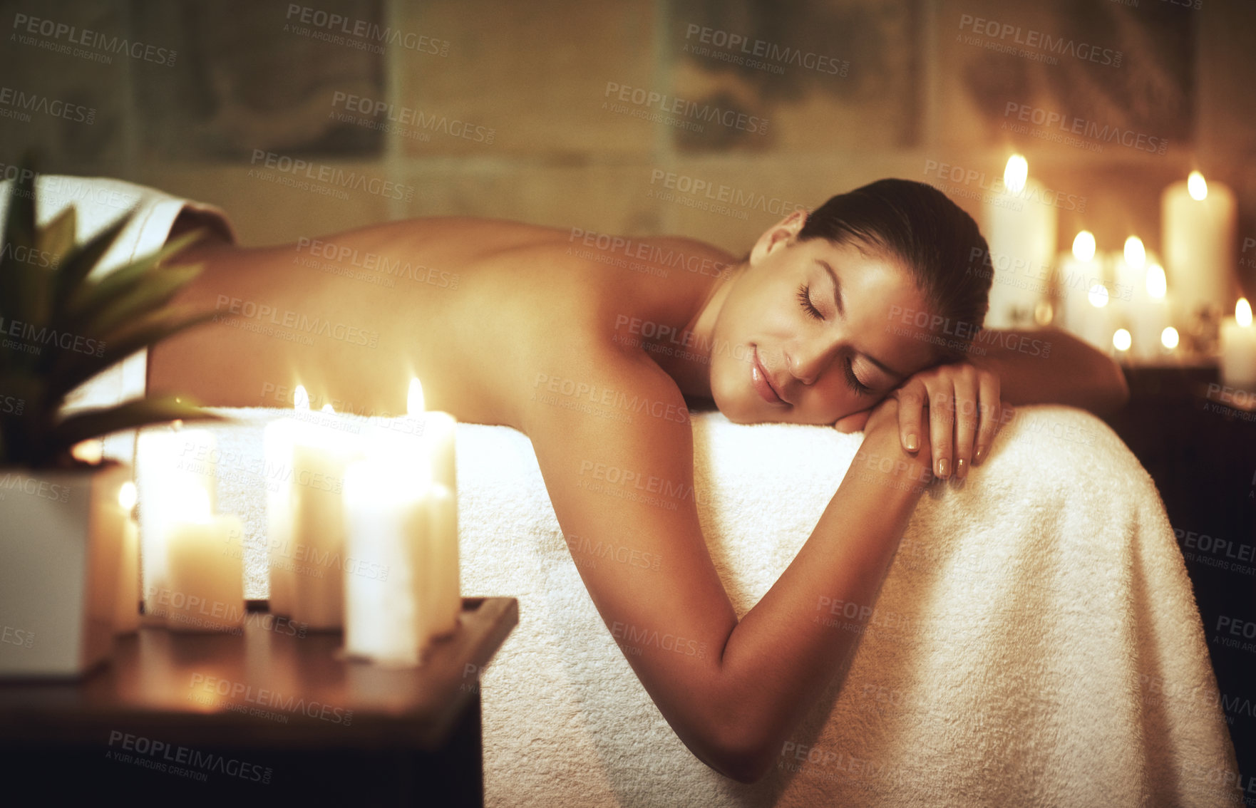 Buy stock photo Woman, relax and massage bed in salon for glow, wellness and cosmetics with candles. Zen, beauty and sleeping with peace after aromatherapy, deep tissue and stress relief in spa with oil for luxury