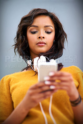 Buy stock photo Girl, streaming and phone for music online with headphones, app and download podcast or audiobook. Woman, typing and reading news of hip hop artist on website or listening to album, playlist or sound