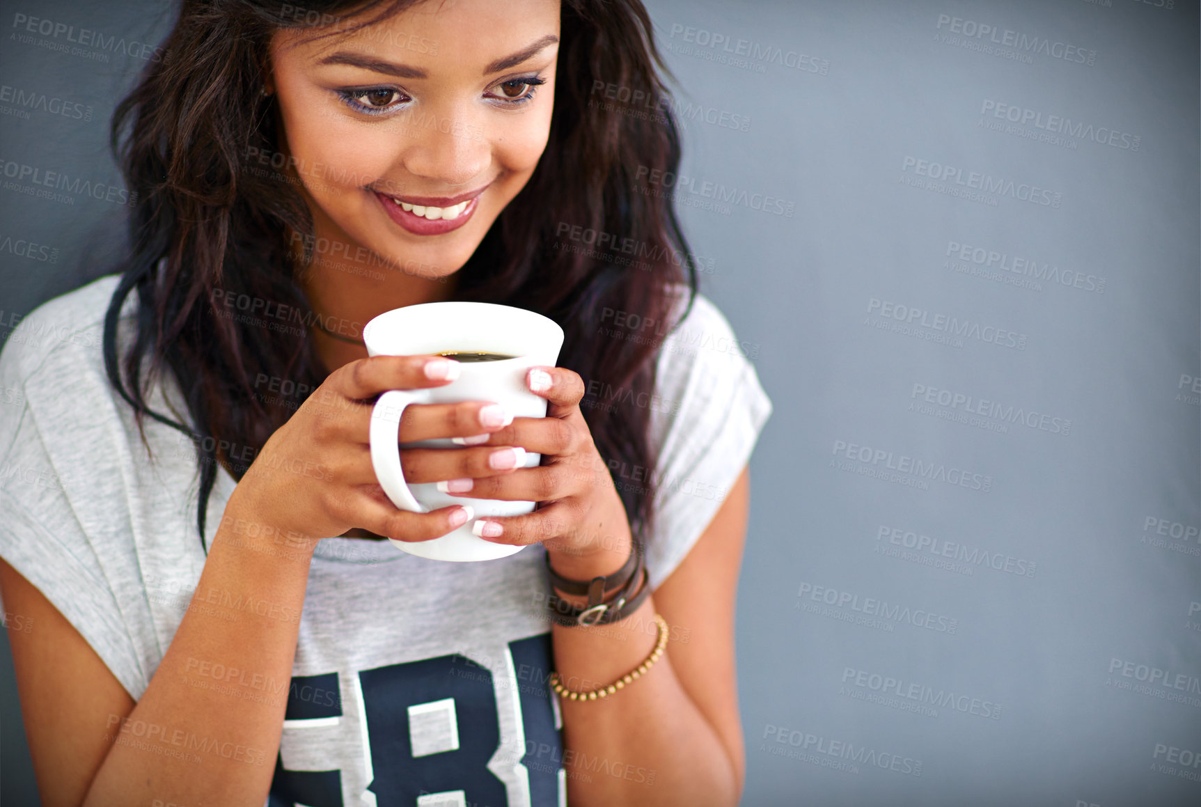 Buy stock photo Happy girl, drinking and coffee with cup for morning, caffeine or beverage on a gray studio background. Female person, brunette or model with smile for latte, cappuccino or espresso on mockup space