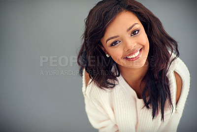 Buy stock photo Studio portrait of an attractive young woman posing against a gray background