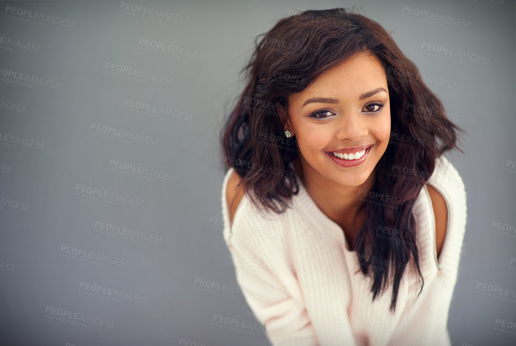 Buy stock photo Studio portrait of an attractive young woman posing against a gray background