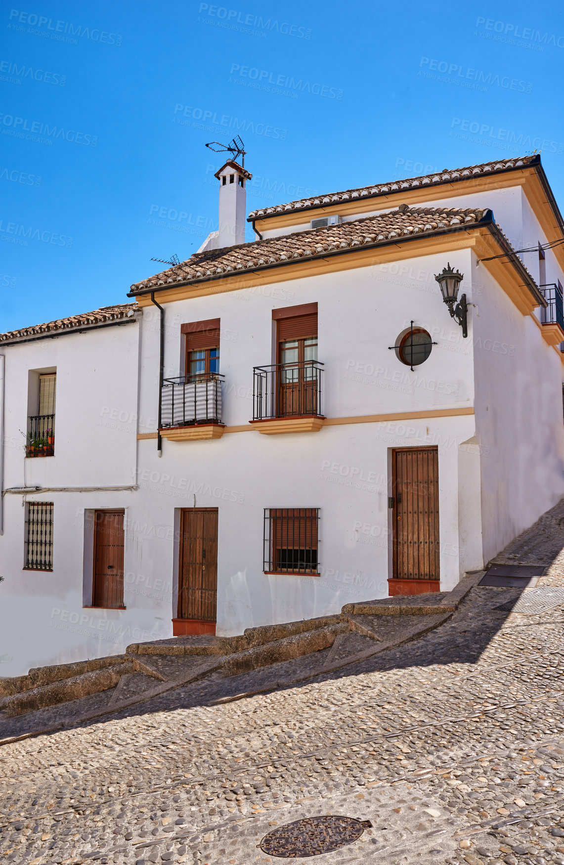 Buy stock photo Building, road and town outside with architecture, travel and exploration with blue sky or aesthetic. Infrastructure, village and street outdoor for holiday, vacation and tourist location in Spain