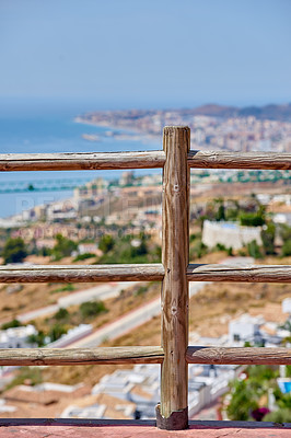 Buy stock photo Railing, city view and outdoor travel for sightseeing, tourism and urban Malaga for peace or calm. Trip, Spain vacation and town scenery in environment, wooden fence and holiday break in Europe