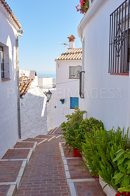 Buy stock photo Brick, path and plants by houses for architecture, buildings and travel or exploration in Spain. Mijas, old city and whitewash homes for heritage, history and village design in Europe for aesthetic