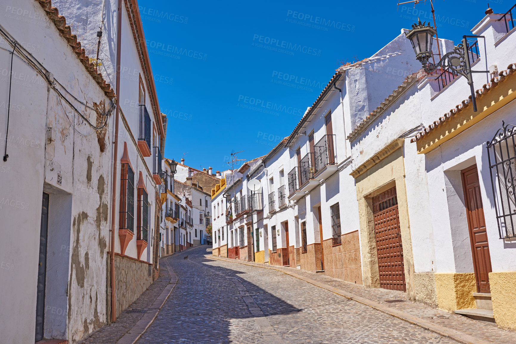 Buy stock photo Narrow street, buildings and ancient architecture for village travel, history tourism and vintage location. Urban, neighborhood and city with traditional culture, holiday sky and destination in Spain