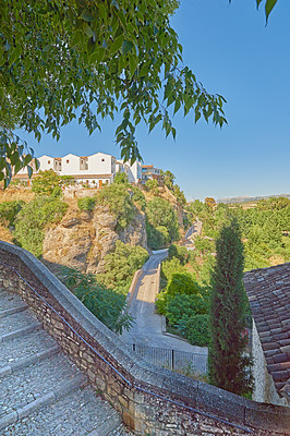 Buy stock photo Nature, wall and buildings in ancient city for travel, exploring or holiday destination with history. Trees, town and vintage houses with village architecture landscaping for vacation or getaway.