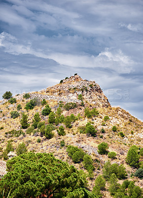 Buy stock photo Outdoor, hill and village in nature, mountain and mockup space of sky, bush and clouds in environment. Travel, countryside and landscape of cliff, property and history of location, valley and Spain