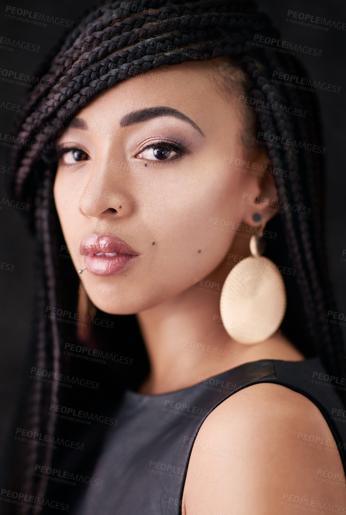 Buy stock photo Studio portrait of a beautiful young woman posing against a black background