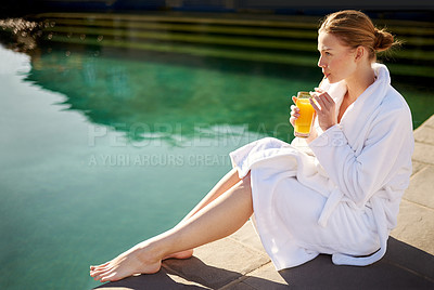 Buy stock photo Shot of an attractive young woman sipping a drink by the pool