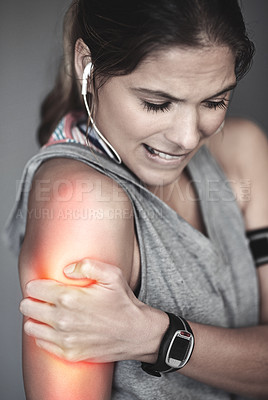 Buy stock photo Cropped shot of a young woman holding her injured shoulder that's highlighted in red