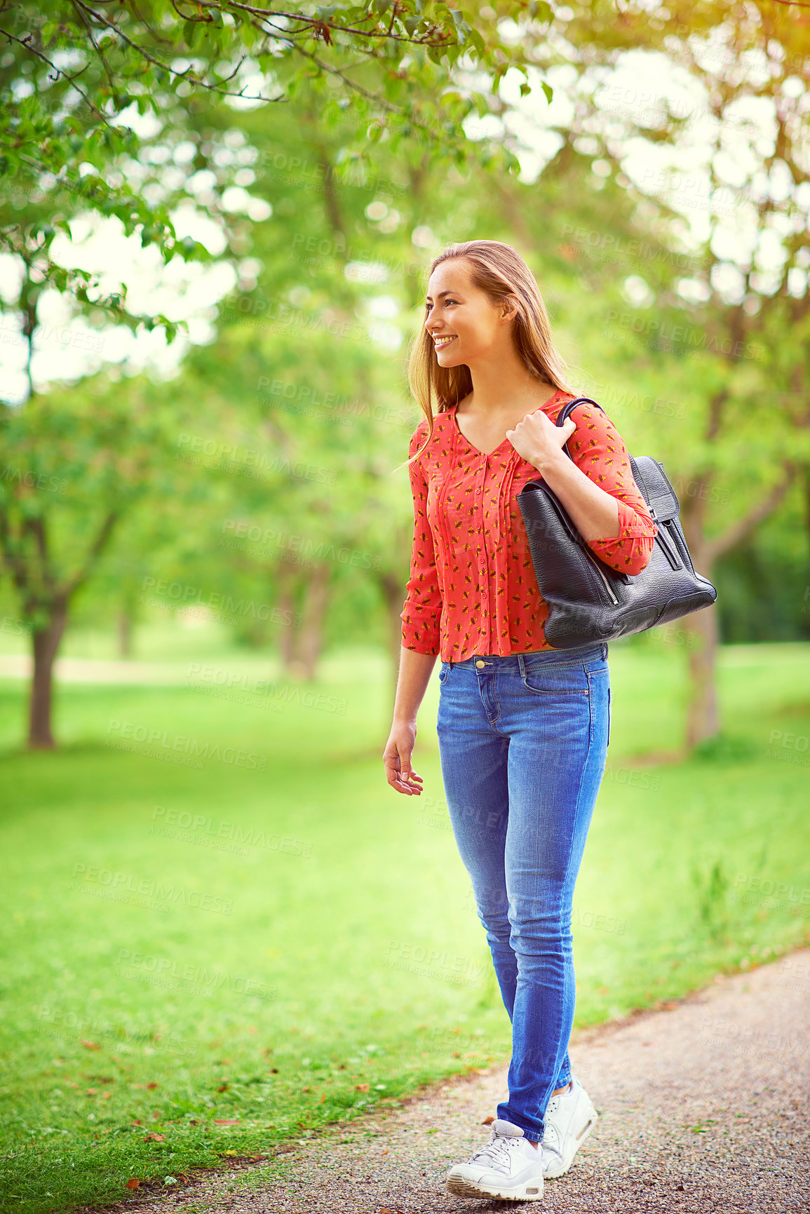 Buy stock photo Shot of a young woman on a walk through the park