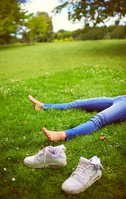Buy stock photo Cropped shot of a woman relaxing on the grass at a park